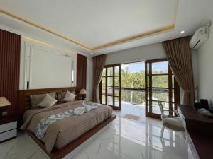 a bedroom with a large bed and a balcony at Royal Maharani Payogan in Ubud +25 photos
