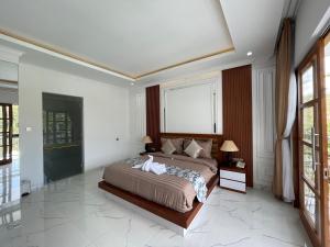 a bedroom with a bed and a large window at Royal Maharani Payogan in Ubud
