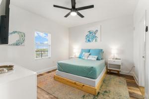 a white bedroom with a bed and a ceiling fan at Luxurious 4 Bedroom Condo! Gulf Views! Sleeps 10 & Easy Beach Access! by Dolce Vita Getaways PCB in Panama City Beach