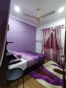 a purple bedroom with a bed and a rug at Homestay Temerloh Jaya in Temerloh