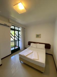 a bedroom with a bed and a large window at Spazio Vital Apartments in Florianópolis