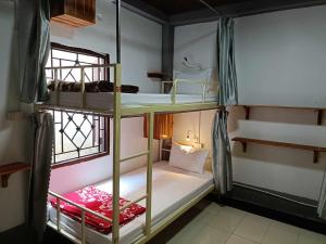 um quarto com 2 beliches e uma janela em City Backpackers em Luang Prabang