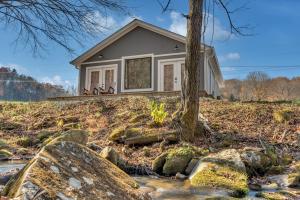 een huis op een heuvel met rotsen voor bij Getaway Cottage - Creek Front, WIFI, Free Attraction Tickets in Cosby