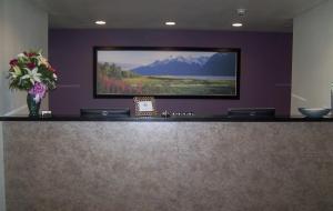 a waiting area with a large television on a wall at Aspen Suites Hotel Haines in Haines