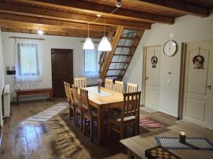 a dining room with a wooden table and chairs at Török Kulcsosház in Băile Homorod