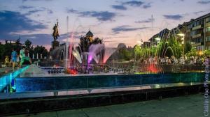 a fountain in a city with people standing around it at Sweet Homme in Craiova
