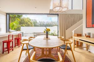 a kitchen and dining room with a table and chairs at Cooee -Brand new with private pool 350m to beach! in Byron Bay