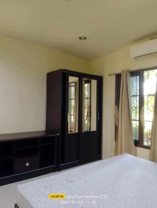 a bedroom with a bed and a black cabinet at 2 one bedroom houses 400 meters from the deach in Amphoe Koksamui