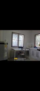 ein Wohnzimmer mit einem Tisch und 2 Fenstern in der Unterkunft 2 one bedroom houses 400 meters from the deach in Nathon Bay