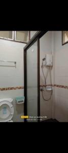 a bathroom with a toilet and a shower stall at 2 one bedroom houses 400 meters from the deach in Amphoe Koksamui