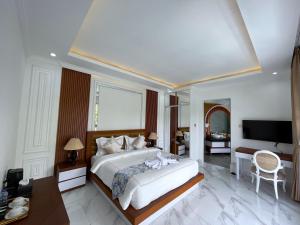 a bedroom with a large bed and a television at Royal Maharani Payogan in Ubud