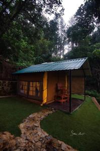 a gazebo with a table and a chair in a yard at Eco Wild Glamping Bambarakanda 