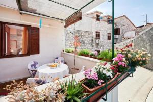 een balkon met een tafel en bloemen erop bij Apartments and rooms Jare - in old town in Trogir