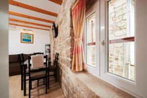 een kamer met een stenen muur en een raam bij Apartments and rooms Jare - in old town in Trogir