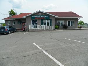 a motel room with a sign on the side of the building at Hilltop Motel & Restaurant in Grand Falls