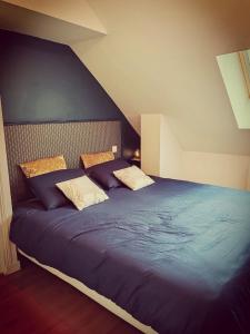 una camera da letto con un grande letto blu con due cuscini di La Parenthèse a Betton Altre 15 foto