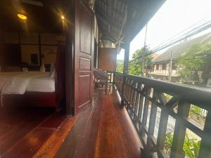 a bedroom with a bed on a balcony at XiengThong KhounPhet GuestHouse in Luang Prabang