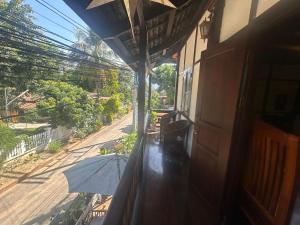 an umbrella sitting on the balcony of a house at XiengThong KhounPhet GuestHouse in Luang Prabang