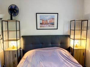 - une chambre avec un lit avec deux étagères et deux lampes dans l'établissement Appartement Port Grimaud 2/4 pers avec grande terrasse, à Grimaud