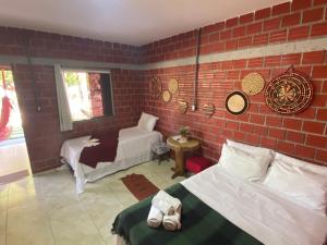 - une chambre avec un mur en briques, un lit et un canapé dans l'établissement POUSADA ALLES, à Santo Amaro