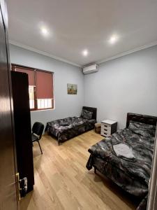 um quarto com duas camas e um sofá em Komitas Avenue Guest House em Yerevan