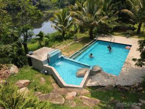 an overhead view of a swimming pool with people in it at Kakulanda Resort in Kurunegala