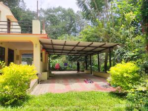 a person walking under a pergola outside of a house at Comfort Cottage in Yercaud