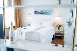 Hotel Keflavik by Reykjavik Keflavik Airport في كيفلافيك: غرفة نوم بيضاء مع سرير أبيض وطاولة +119 صورة