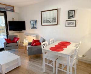 - un salon avec une table blanche et des oreillers rouges dans l'établissement Appartement Port Grimaud 2/4 pers avec grande terrasse, à Grimaud