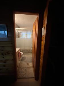 Jolie chambre dans chalet في Le Vaud: باب مفتوح للحمام مع مرحاض