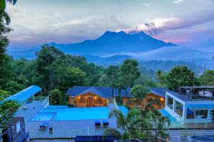 a view of a resort with a mountain in the background at Woodrose Resort in Kalpetta