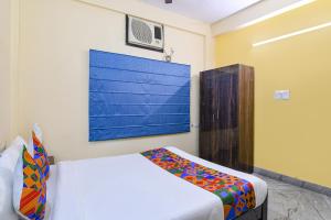 1 dormitorio con 1 cama y una pintura en la pared en FabHotel Sapphire Comfort, en Calcuta