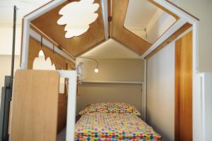 a bed in a small room with a ceiling at Taitung Ohana Sky Hostel in Taitung City