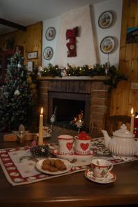 a table with cookies and a fireplace with a christmas tree at LA GROTTA in Subiaco
