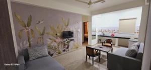 a living room with a couch and a table in it at The Grand ND Resort- Kanha Tulsi Heights Behind Prem Mandir in Vrindāvan