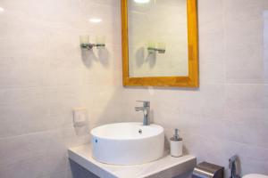 a white bathroom with a sink and a mirror at Ramzu Villa Thoddoo in Thoddoo