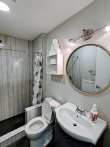 a bathroom with a toilet and a sink and a mirror at Hillcrest Hideaway in Airdrie
