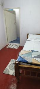 um quarto com uma cama e uma porta que leva a um quarto em Raagabynature home stay em Gendehalli