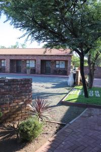 a brick house with a tree in front of it at Big D Accommodation & guesthouse in Northam