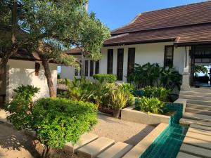 een huis met bomen en planten ervoor bij Ban Laem Set - Beachfront Private Luxury Villa in Laem Set Beach