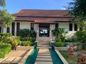 a house with a pathway leading to the front door at Ban Laem Set - Beachfront Private Luxury Villa in Laem Set Beach
