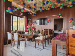 uma sala de estar com mesa e cadeiras e balões no tecto em Mussoorie Homestay em Mussoorie