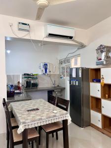 a kitchen with a table with chairs and a refrigerator at Good Stay 2BHK Apartment - 702 in Dabolim