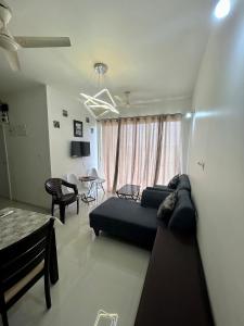 a living room with a couch and a table at Good Stay 2BHK Apartment - 702 in Dabolim