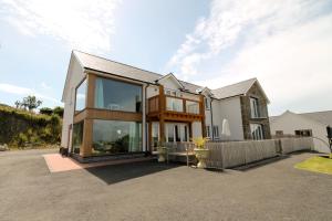 a house with large glass windows on a driveway at Cambrian View in Aberystwyth