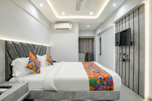 um quarto de hotel com uma cama e uma televisão em FabHotel Aahan em Nova Bombaim