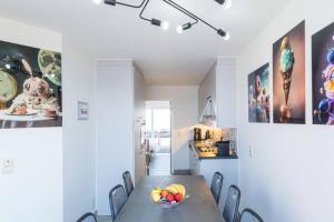 a dining room table with chairs and a bowl of fruit on it at Prachtig zeezicht tot 6 personen met garage in Middelkerke