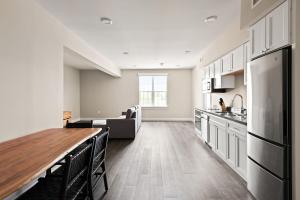 a kitchen with white cabinets and a wooden table at Holy Angels Bywater Hotel and Residences in New Orleans
