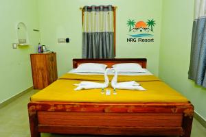 a bedroom with a bed with two white towels at NRG Resort in Yelagiri