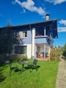 羅森海姆的住宿－Alpenblick Pang，院子里带野餐桌和椅子的房子